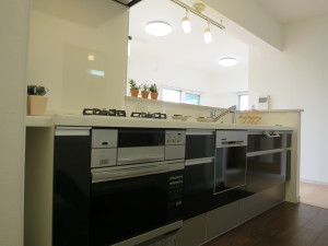 ダークカラーの落ち着いた色調のキッチン